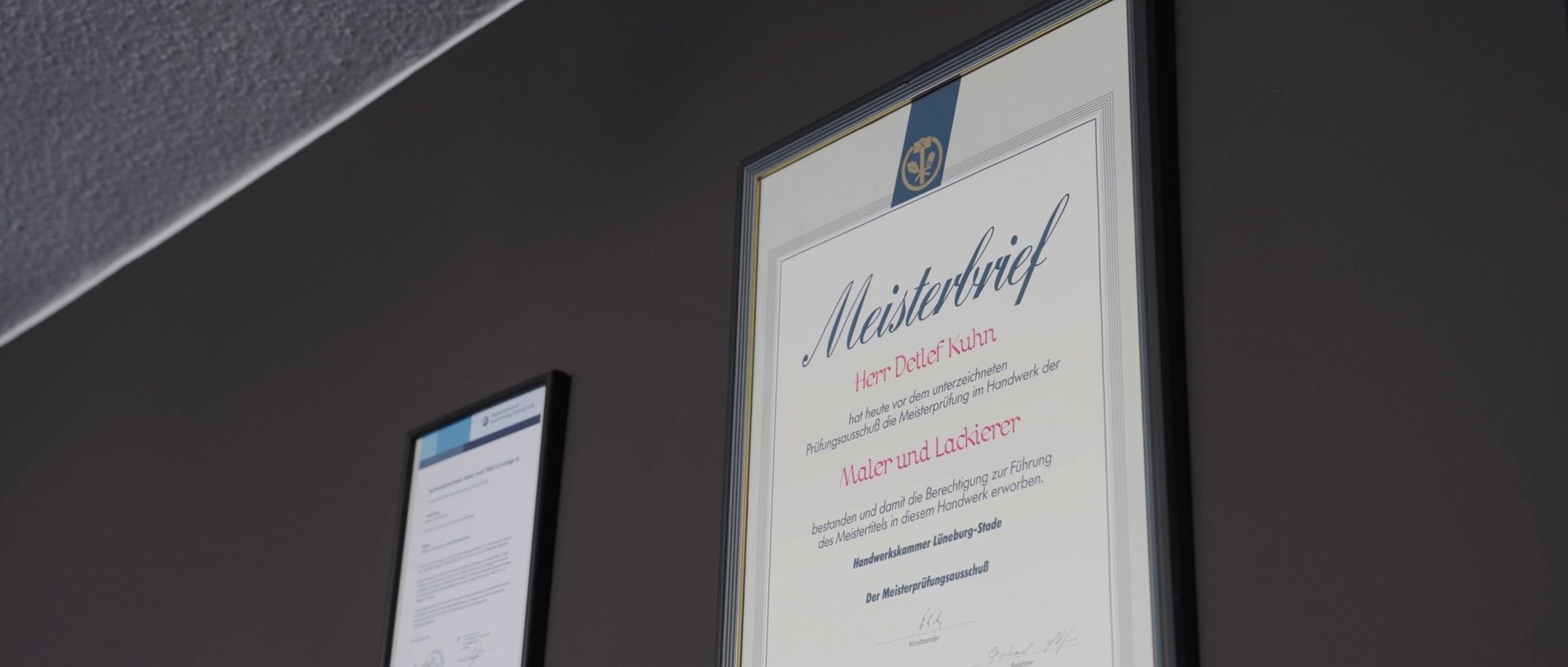 Eine teilweise fertiggestellte Badezimmerecke mit einer grauen Wand mit Sanitärarmaturen und einer gelben Badewanne. Heller Holzfußboden sichtbar.