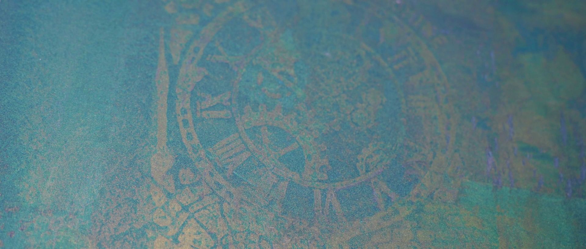 Abstrakter blauer Hintergrund mit schimmernden Farbverläufen, auf dem ein Ziffernblatt mit römischen Ziffern und verschnörkelten Details zu erkennen ist.